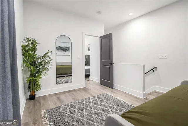 a view of a hallway with wooden floor and a living room