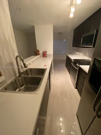 a kitchen with a sink and a stove top oven