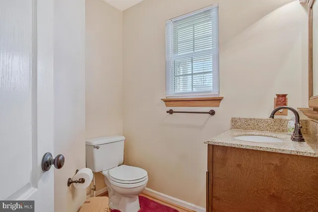 a bathroom with a sink toilet and window