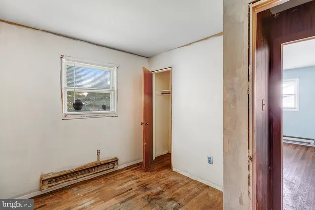 a view of a room with wooden floor and a window