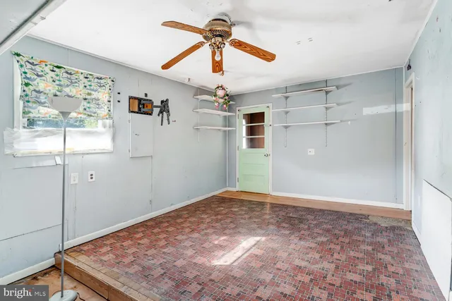 a view of a livingroom with a chandelier fan and windows