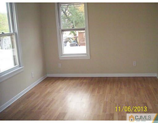 243 Walnut Street Dunellen, NJ 08812 - Photo 5 of 18 an empty room with wooden floor and windows