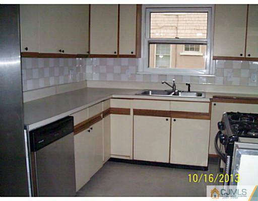 243 Walnut Street Dunellen, NJ 08812 - Photo 6 of 18 a kitchen with stainless steel appliances granite countertop a sink stove and cabinets