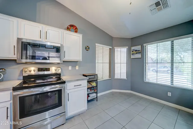 a kitchen with granite countertop a stove a microwave and wooden cabinets