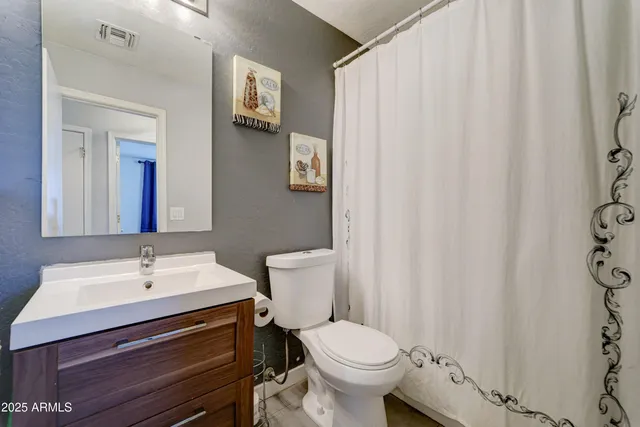 a bathroom with a sink a toilet and a mirror