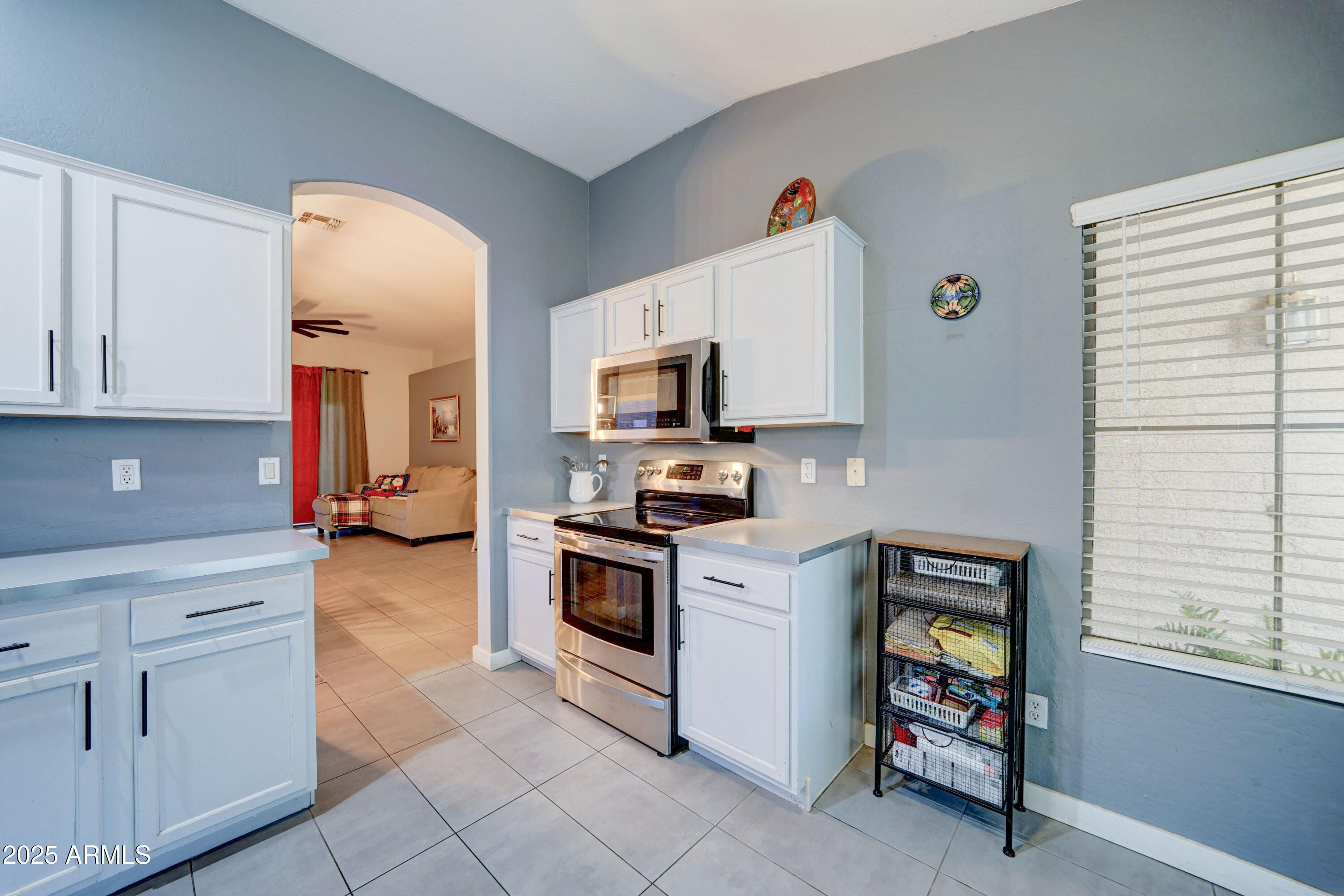 5515 South 15th Way Phoenix, AZ 85040 - Photo 10 of 26 a kitchen with granite countertop a stove top oven microwave and cabinets