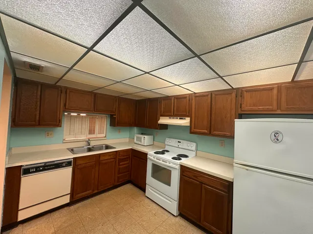 a kitchen with a stove sink and cabinets