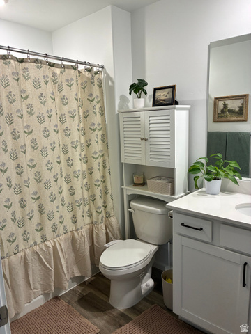 673 West 1920 South, Unit 1063 Provo, UT 84601 - Photo 9 of 15 Bathroom featuring a white vanity with a quartz-finish countertop, wood-finish flooring, and a built-in over-toilet storage unit