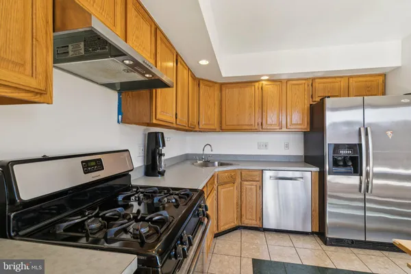 a kitchen that has a refrigerator and a stove top oven