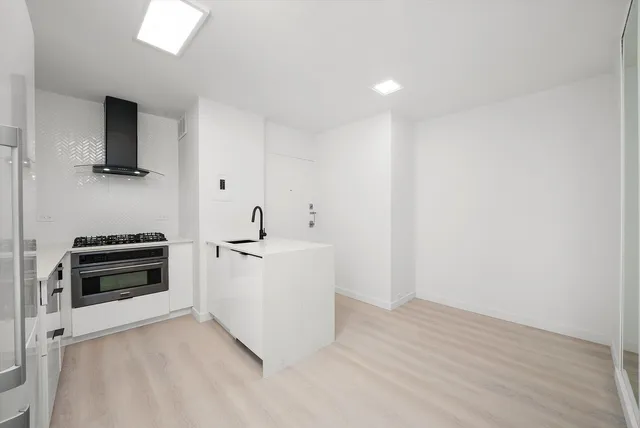 a view of kitchen with stainless steel appliances a stove top oven