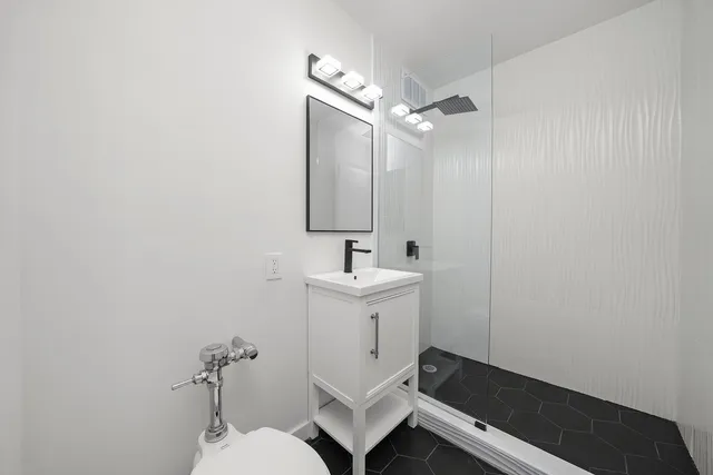 a bathroom with a sink a toilet and shower