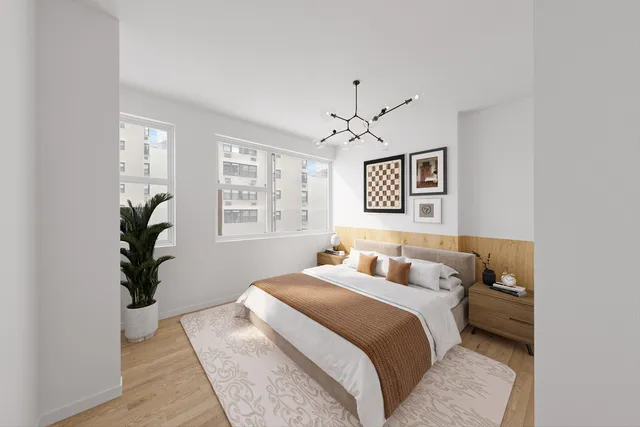 a bedroom with a large bed and a chandelier