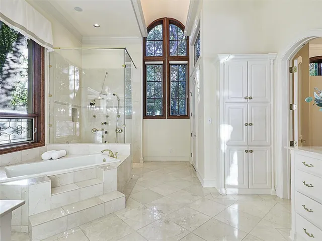 a spacious bathroom with a tub shower and mirror