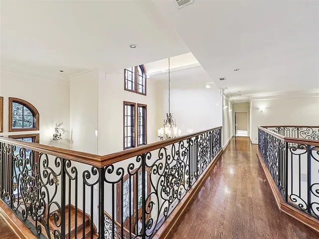 a view of a hallway with wooden floor and stairs