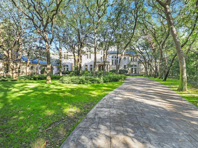 a view of a white house with large windows and a small yard