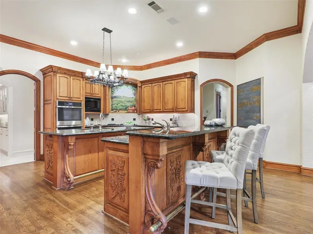 a kitchen with granite countertop a table chairs stove a refrigerator and kitchen view