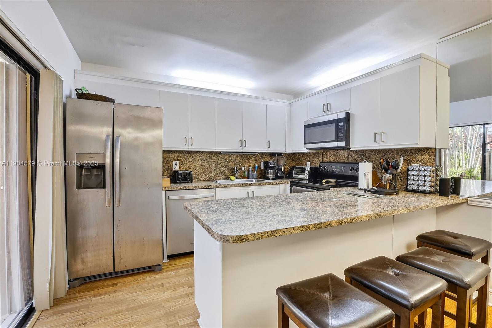 9927 Northwest 6th Place Plantation, FL 33324 - Photo 15 of 43 a kitchen with stainless steel appliances granite countertop a refrigerator a stove top oven a sink and dishwasher