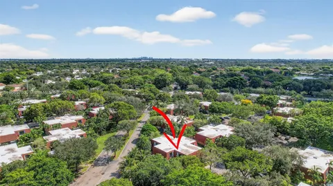 an aerial view of residential houses with outdoor space and trees