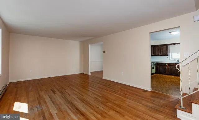 a view of a hallway with wooden floor and staircase