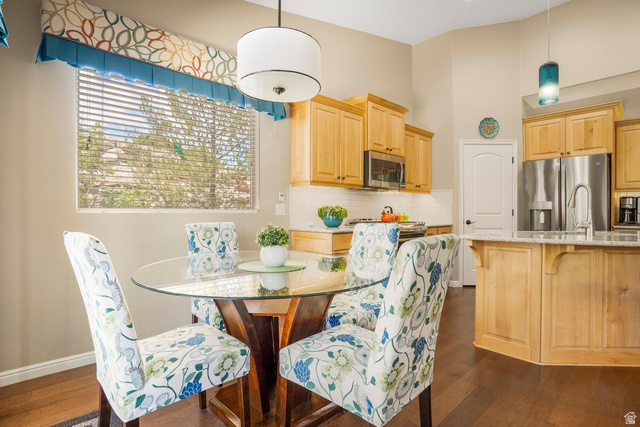 1587 Whitestone Drive St. George, UT 84790 - Photo 12 of 36 Open-concept kitchen and dining area featuring hardwood flooring, light wood cabinetry, stainless steel appliances, and a kitchen island with seating