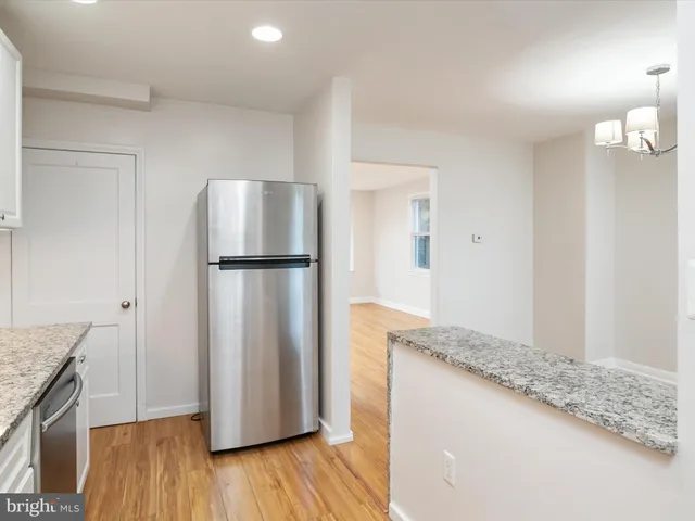 a kitchen with granite countertop a refrigerator and a sink