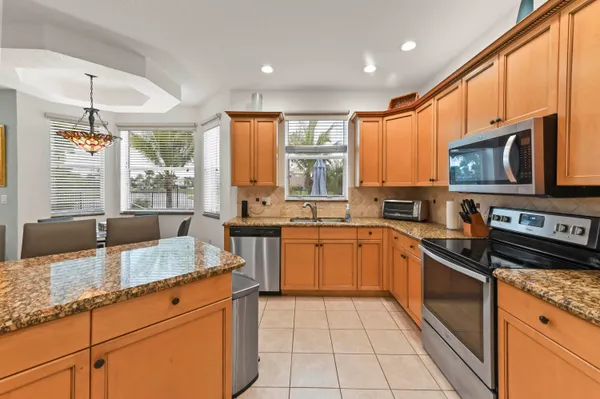 a kitchen with granite countertop a stove sink and microwave