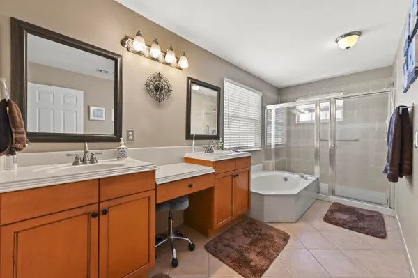 a large bathroom with a double vanity sink a toilet a mirror and bathtub