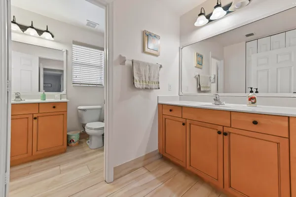 a spacious bathroom with a toilet sink double vanity and mirror