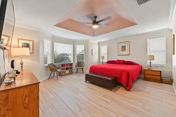 a spacious bedroom with a bed and wooden floor
