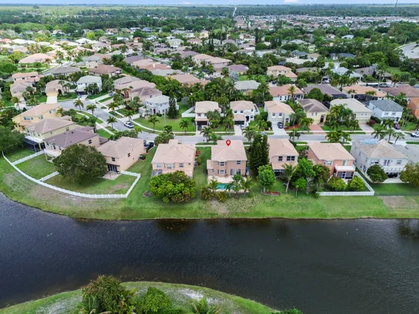 an aerial view of a house with a yard and lake view