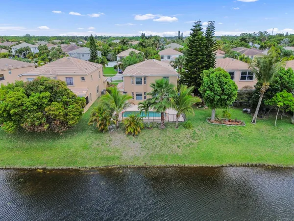 an aerial view of a house with garden space and a lake view