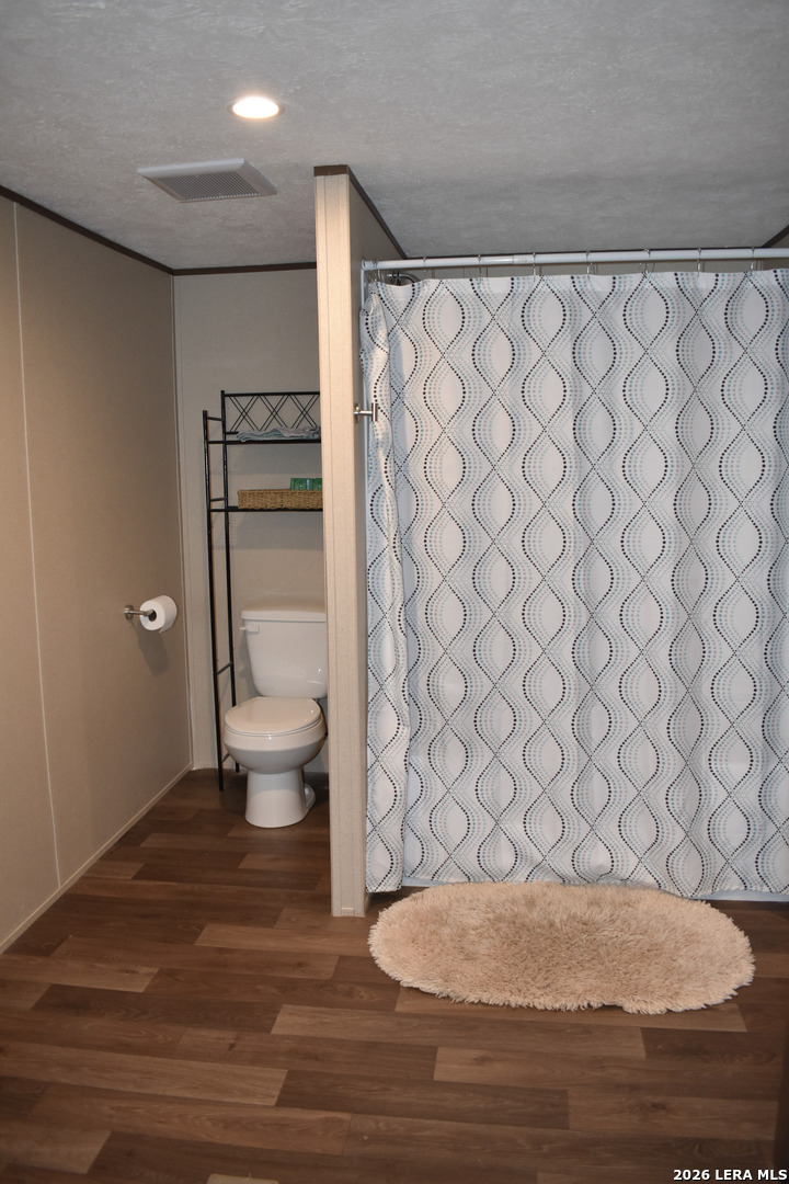 17016 Rancho Escondido Atascosa, TX 78002 - Photo 8 of 14 a bathroom with a toilet and a shower curtain