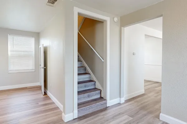 a view of a hallway with wooden floor and entryway