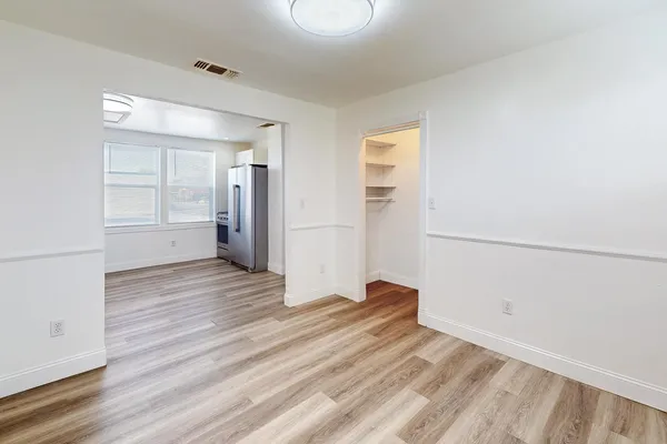 a view of empty room with wooden floor