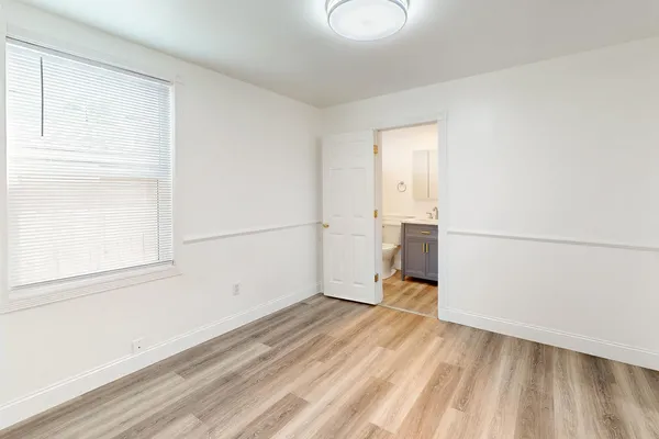 a view of empty room with wooden floor
