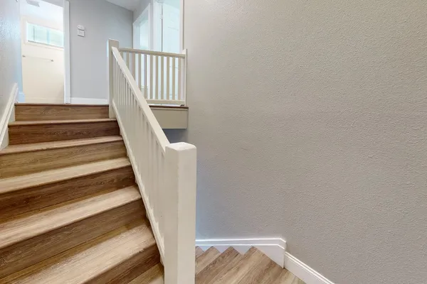 a view of staircase with wooden floor and white walls