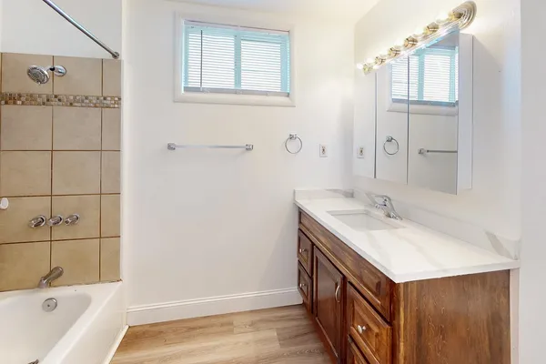 a bathroom with a tub sink and mirror