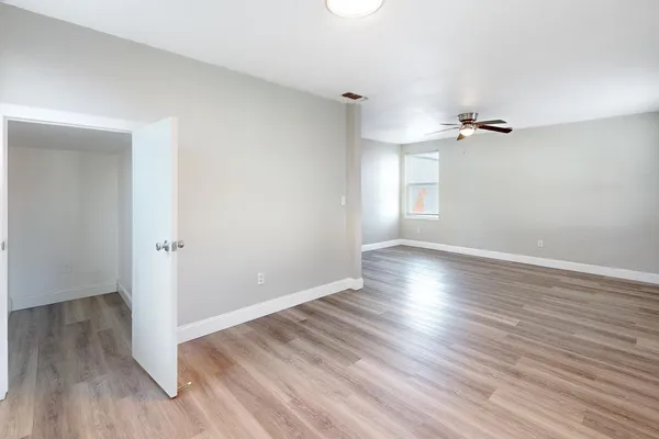 an empty room with wooden floor and windows