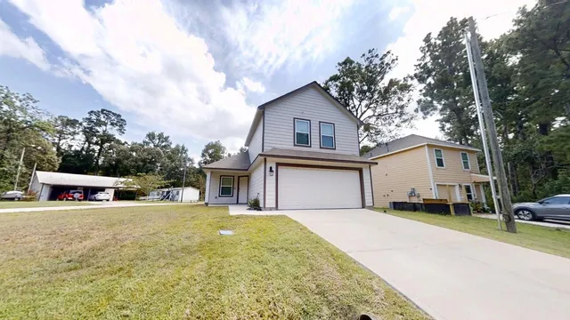a white house that has a tree in front of it