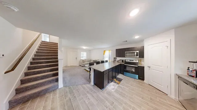 a kitchen with a refrigerator and a stove top oven