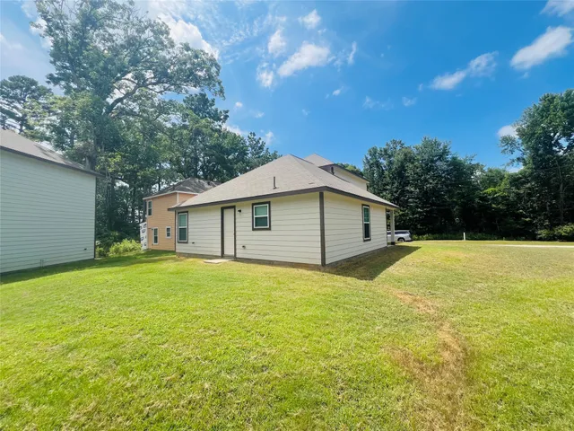a front view of house with yard and trees in the background