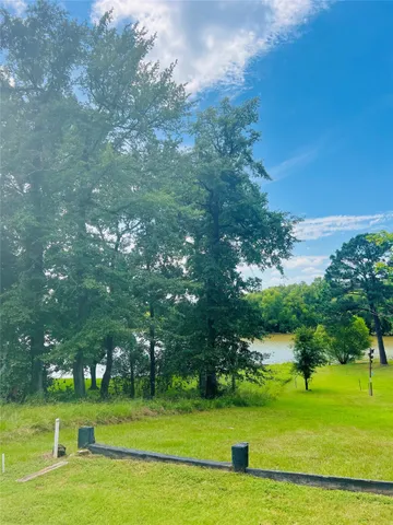 a backyard of a house with table and chairs under an umbrella