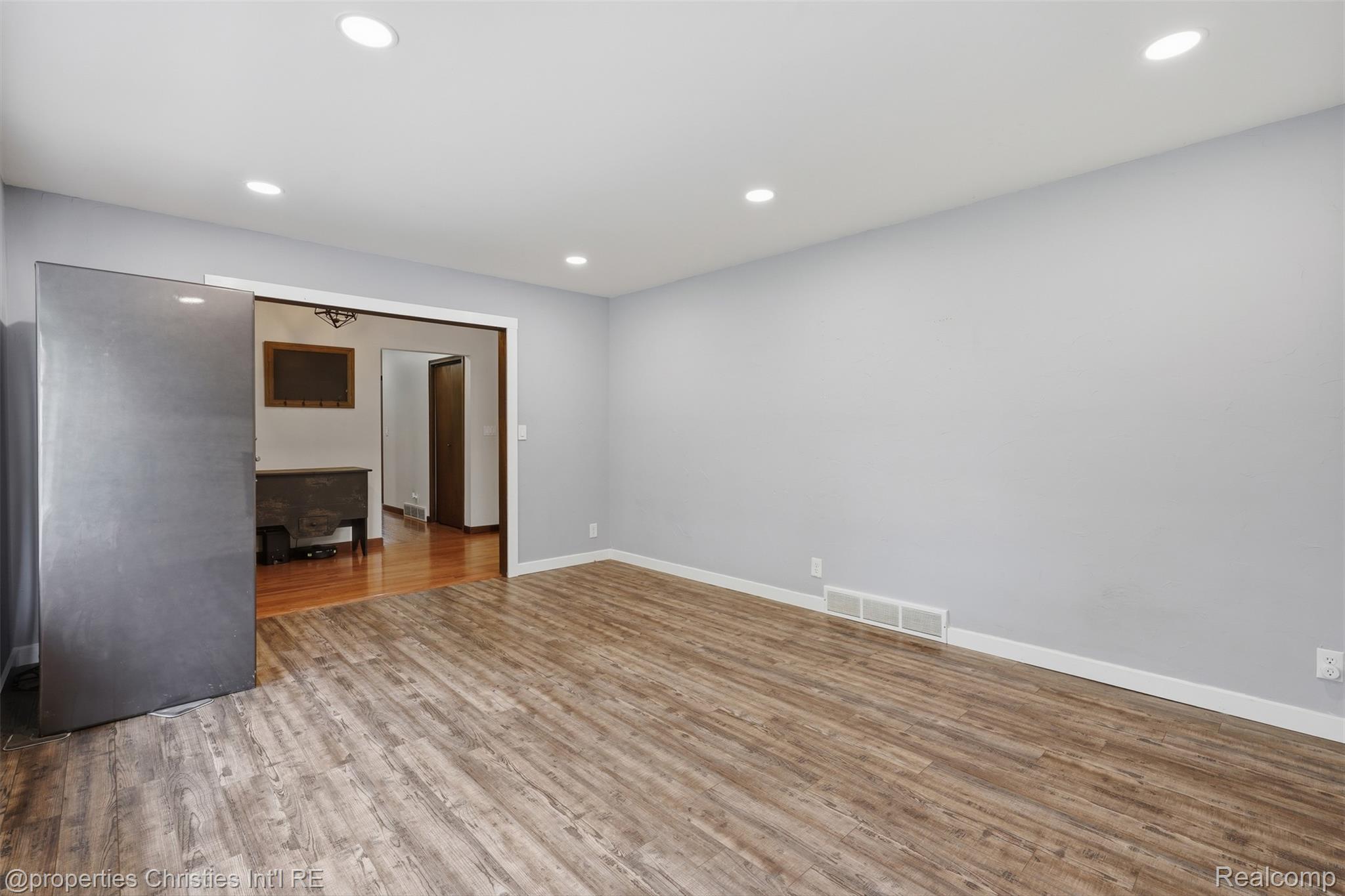 4030 Textile Road Ypsilanti, MI 48197 - Photo 8 of 58 Recessed lighting, wood-finish flooring, light grey wall paint, and a sliding barn door