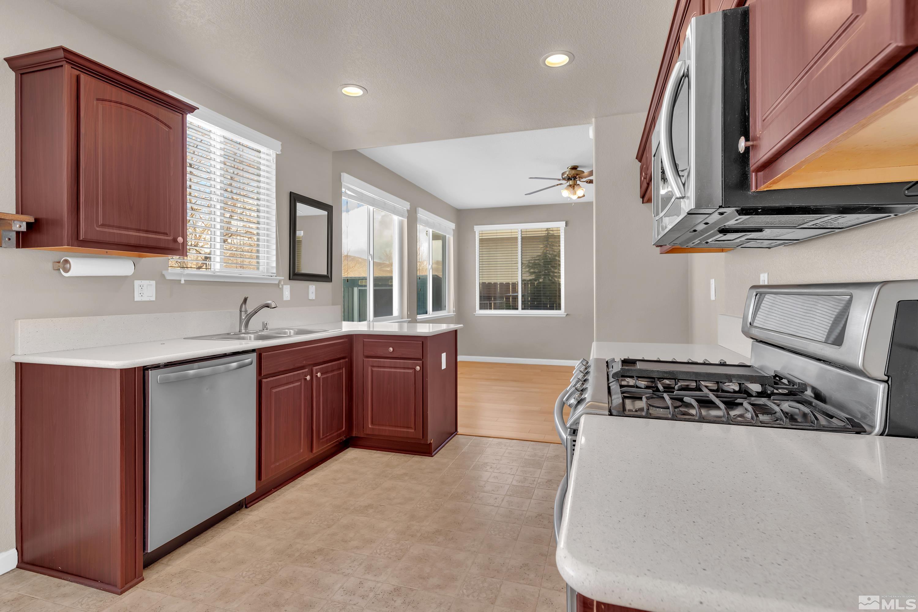 2325 Lincoln Meadows Drive Reno, NV 89521 - Photo 14 of 40 a kitchen with stainless steel appliances granite countertop a sink stove and cabinets
