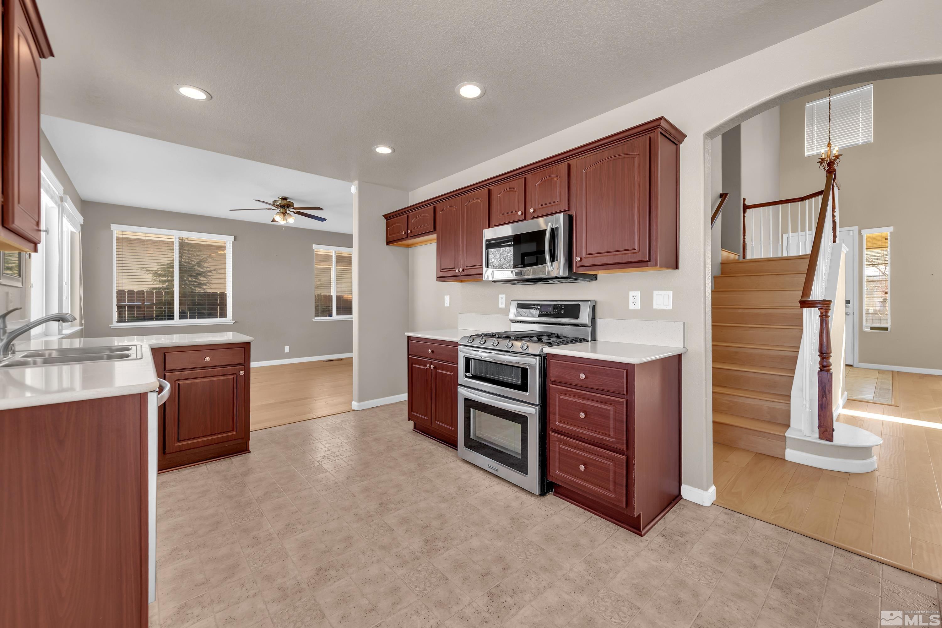 2325 Lincoln Meadows Drive Reno, NV 89521 - Photo 16 of 40 a kitchen with stainless steel appliances kitchen island granite countertop a refrigerator stove and sink