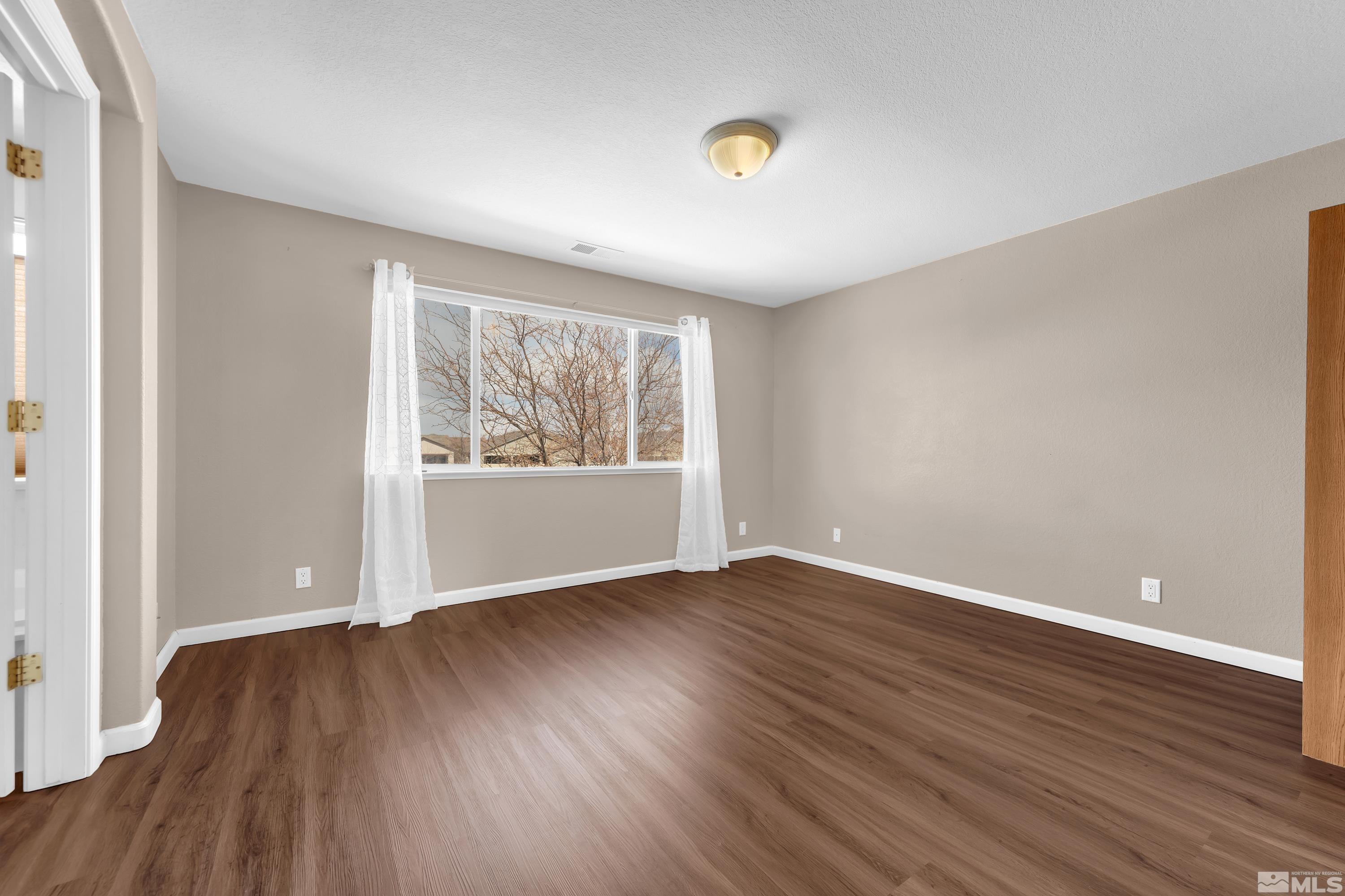2325 Lincoln Meadows Drive Reno, NV 89521 - Photo 20 of 40 an empty room with wooden floor and windows