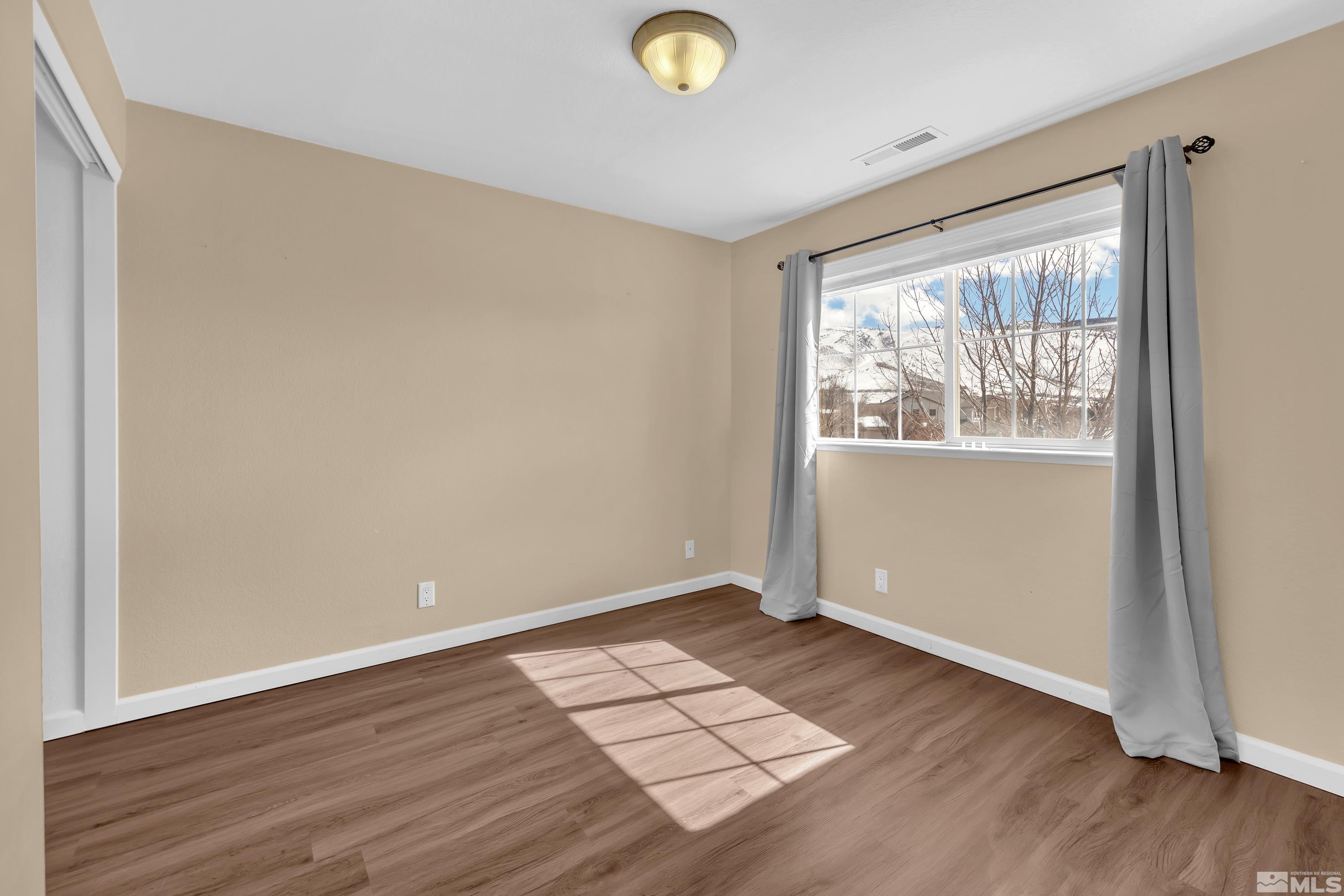 2325 Lincoln Meadows Drive Reno, NV 89521 - Photo 26 of 40 an empty room with wooden floor and windows