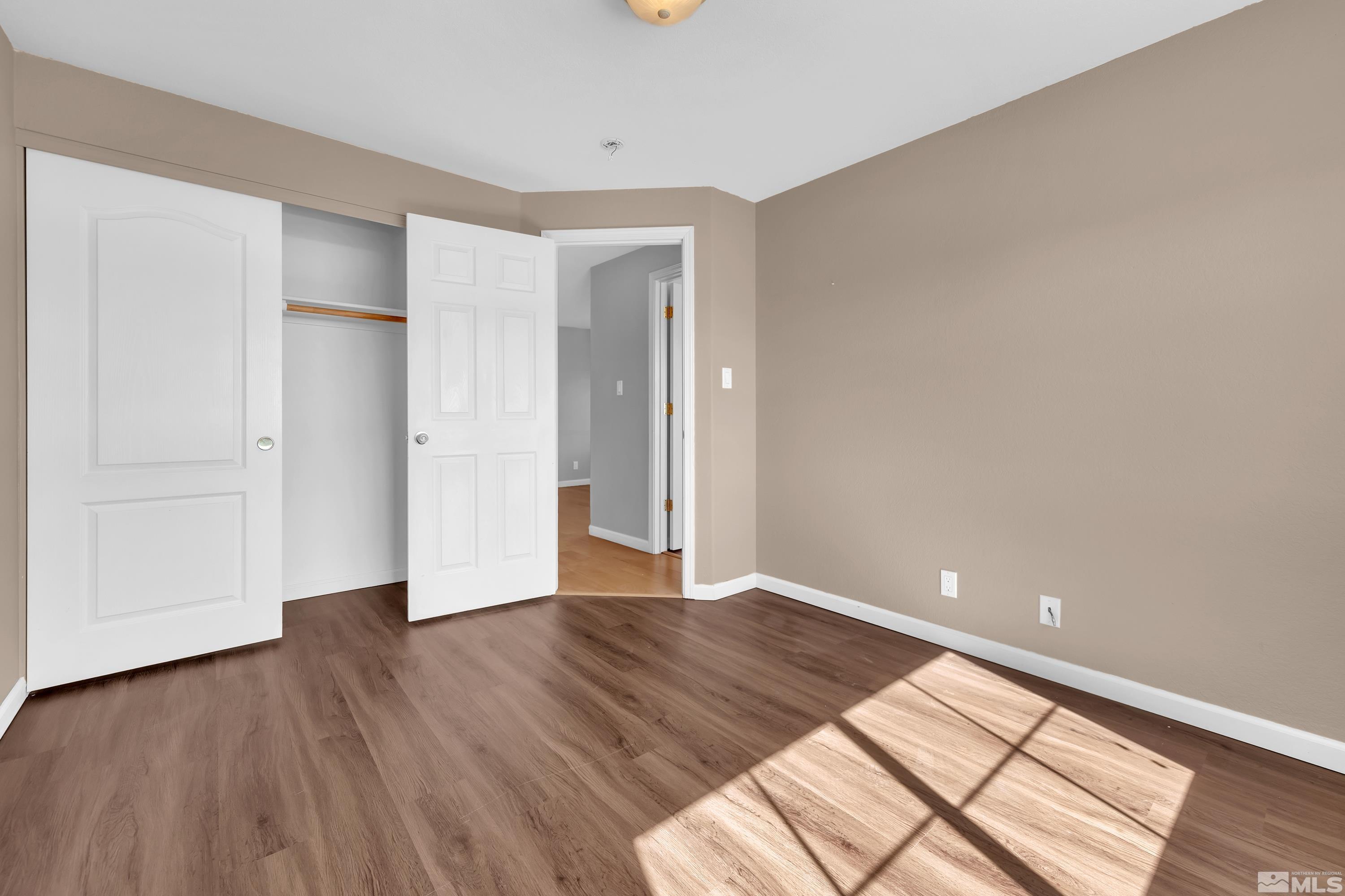 2325 Lincoln Meadows Drive Reno, NV 89521 - Photo 29 of 40 a view of an empty room with wooden floor and a window