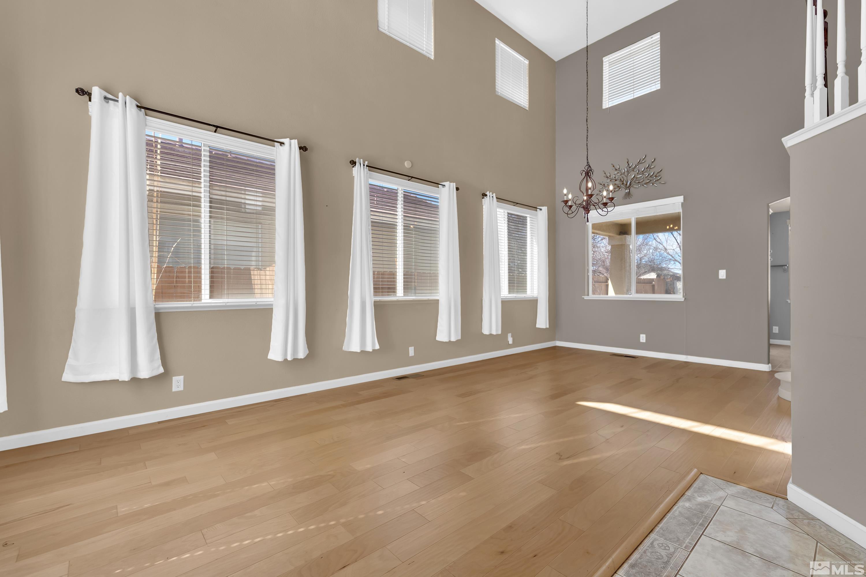 2325 Lincoln Meadows Drive Reno, NV 89521 - Photo 7 of 40 a view of an empty room with wooden floor and a window