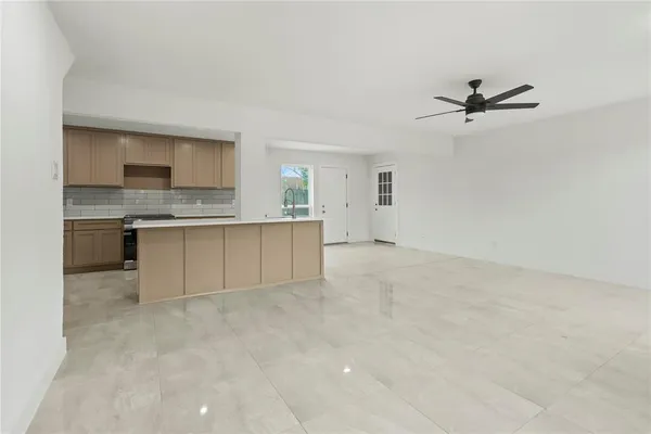 an empty room with a kitchen and a sink